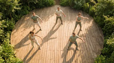 Overhead view of a tai chi class at different skill levels practicing together on a wooden deck