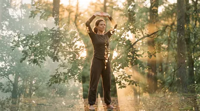Double exposure of a practitioner pressing palms skyward blended with sunlit sage green leaves