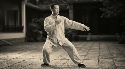 Black and white photograph of a practitioner demonstrating the classic white crane spreads wings posture